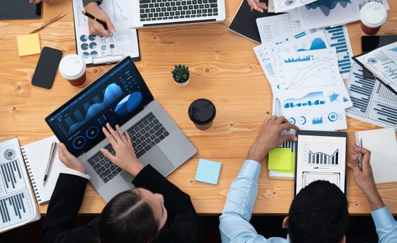 Panorama top view multiracial analyst team use BI dashboard display on laptop screen, analyzing financial data for strategic decision. Fintech analyzes marketing indicators. Concord