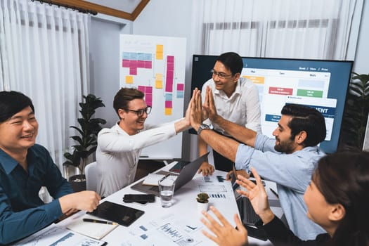 Happy office worker and project manager celebrate in meeting room after successfully achieving business task on time and on schedule. Project management tracking software for business success. Prudent