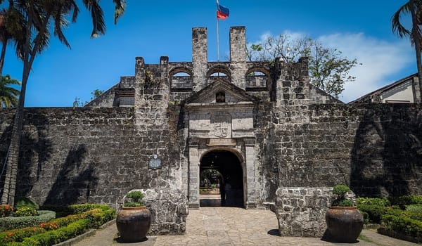 Fort San Pedro in Cebu, Philippines, is a triangular-shaped fortress with lush greenery, historic cannons, and a view of the bustling city