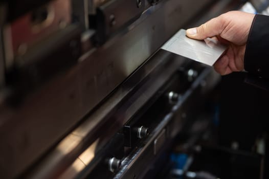 A master bends metal sheets on a machine. Hydraulic Press