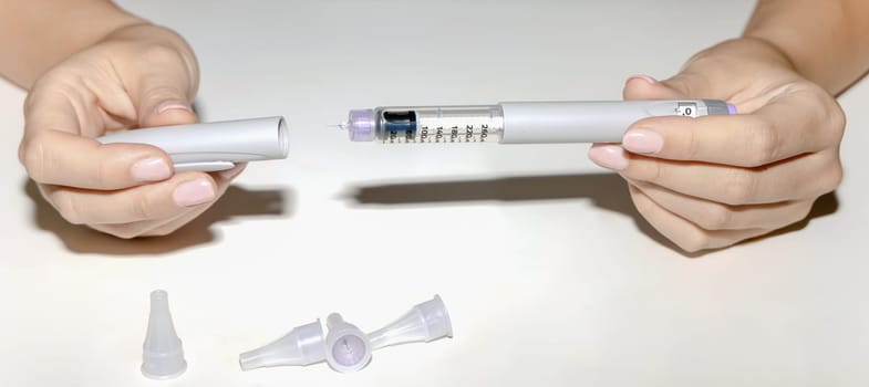 Female hands holding an insulin pen. Ozempic Insulin injection pen or insulin cartridge pen for diabetics. Medical equipment for diabetes parients.