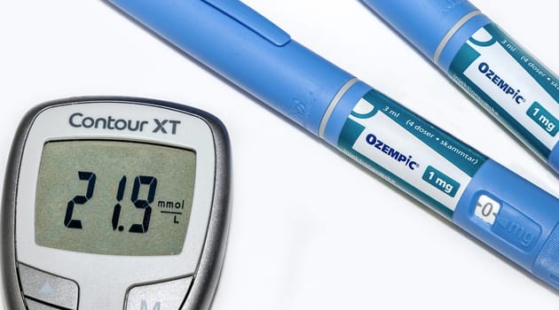 Blood sugar meter with test strips indicates high blood sugar levels and Ozempic injection pen for diabetes. Denmark - February 10, 2024