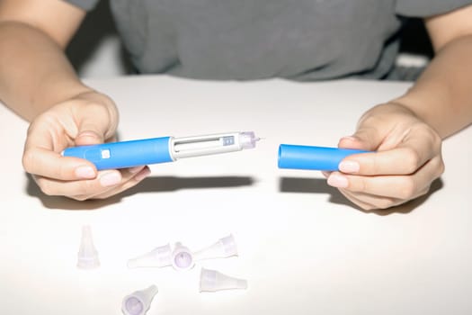 Female hands holding an insulin pen. Ozempic Insulin injection pen or insulin cartridge pen for diabetics. Medical equipment for diabetes parients.