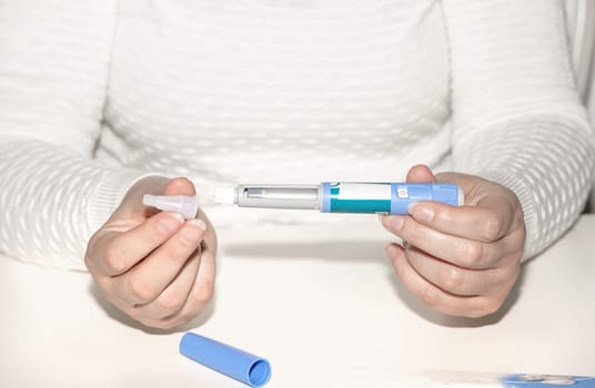 Female hands holding an insulin pen. Ozempic Insulin injection pen or insulin cartridge pen for diabetics. Medical equipment for diabetes parients.