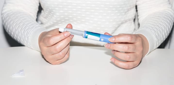Female hands holding an insulin pen. Ozempic Insulin injection pen or insulin cartridge pen for diabetics. Medical equipment for diabetes parients.