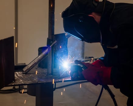Competitions among welders. A man in a protective mask is welding