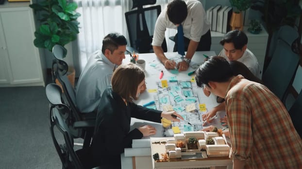 Group of diverse team planning strategy while sitting at table with project plan. Top aerial view of smart business people working together to brainstorm and design house construction. Alimentation.