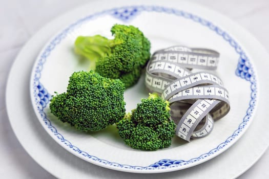 Concept of healthy eating and weight loss. Plate of green broccoli.