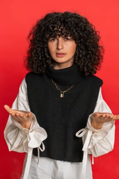 Upset frustrated annoyed woman raising hands in indignant expression, quarreling asking reason of conflict problem why such stubborn. Irritated young girl isolated on red background indoors. Vertical