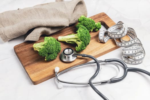 Concept of healthy eating and weight loss. Green broccoli on a cutting board.