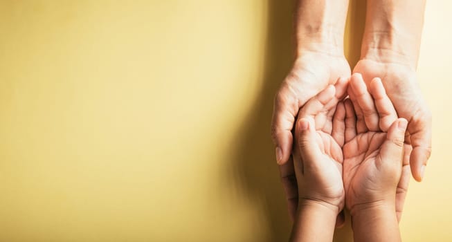 Studio shot, Close-up top view of family hands stacked isolated background. Parents and kid holding empty space together symbolizing support and love. Family and Parents Day concept.