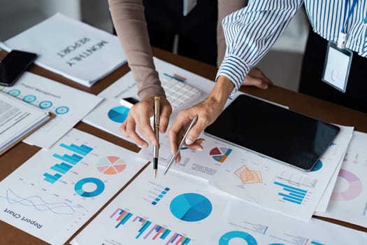 Collaborative business woman meeting hands analyzing financial charts and graphs on office desk for strategic planning.