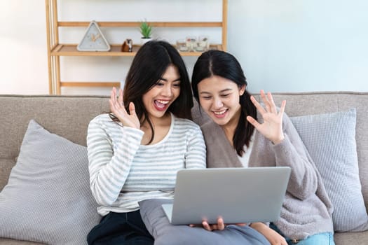 pride month Happy woman lesbian gay lgbt couple using laptop to video call with family, friends. LGBTQ couple concept.