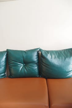 modern leather sofa with pillows at cafe restaurant .