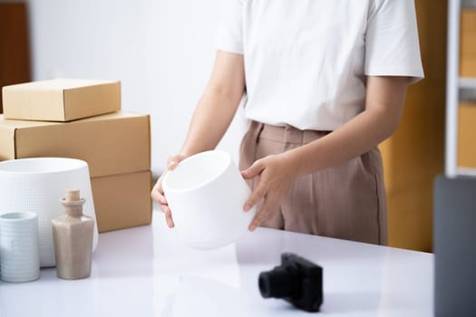 Attentive business owner thoroughly examining a product to ensure top quality before dispatch in her online shop workspace.