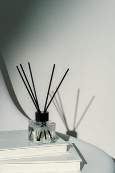 Liquid home perfume in glass diffuser with sticks on chair close up