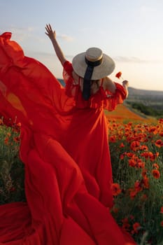 Woman poppy field red dress hat. Happy woman in a long red dress in a beautiful large poppy field. Blond stands with her back posing on a large field of red poppies