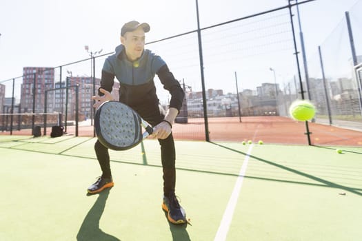 Man playing padel in a green grass padel court indoor behind the net. High quality photo