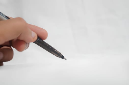 A person is writing with a pen on a white background. High quality photo