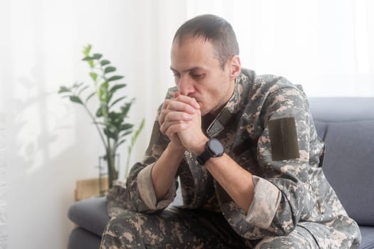 Nervous male military suffering depression, sitting alone at home, PTSD concept. High quality photo