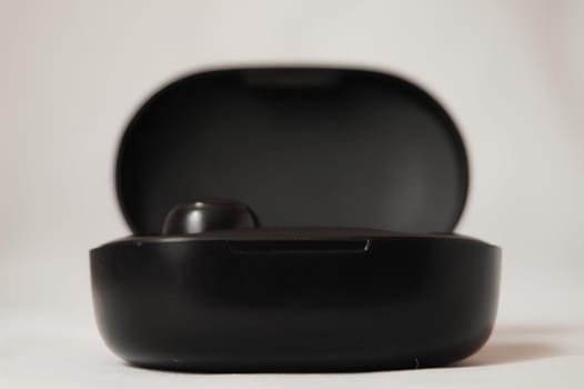 Black Wireless Earbuds Resting in Case. High quality photo