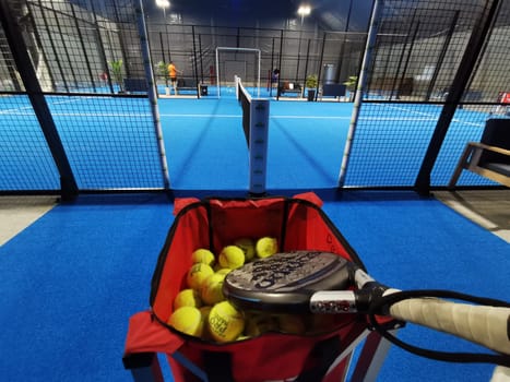 Ukraine Kyiv, April 11 2024: Padel racket adidas and padel ball on a green court . High quality photo