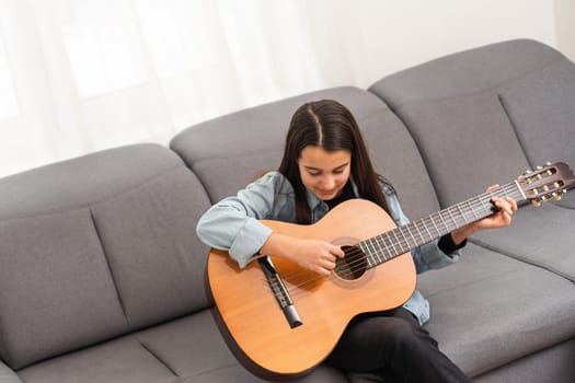 beautiful young girl plays guitar at home. High quality photo