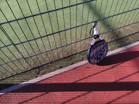 Ukraine Kyiv, April 11 2024: Padel racket adidas and padel ball on a green court . High quality photo