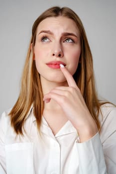 Young Woman in White Shirt Holding Finger to Lips