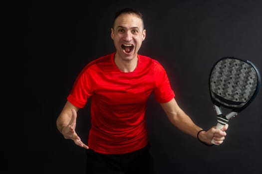 Smiling man with racket and paddle ball dressed in sport clothes isolated background. Front view. High quality photo