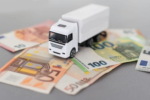 White toy truck lie on dollars, space for text. High quality photo