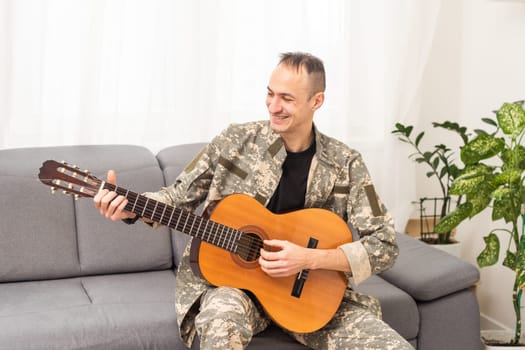 Veteran Guitar Play Concept. Family Meeting. Camouflage Uniform. Resting Together. Feelings Showing. Patriotic Comeback. Paralyzed Soldier. High quality photo