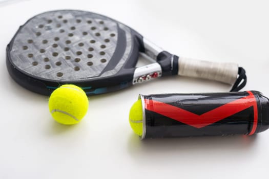 Set of paddle tennis rackets and balls the reflected on white table and white isolated background. Front view. High quality photo