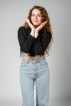 Woman With Curly Hair Standing on Gray Background portrait