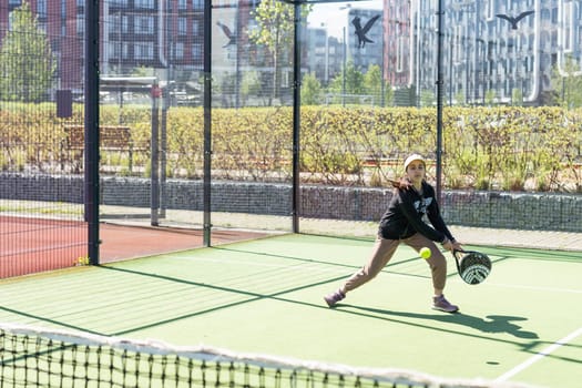Ukraine Kyiv, April 20 2024. happy pretty girl practicing paddle sport on the paddle court. High quality photo