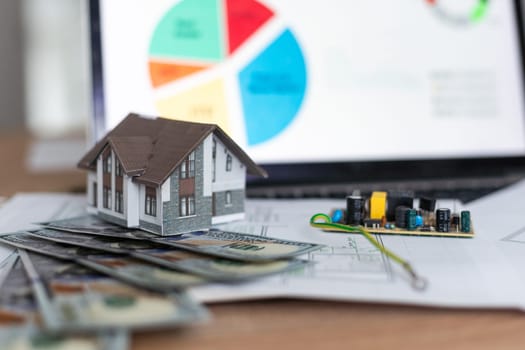 Model house on top of money pile suggesting savings for a house. High quality photo