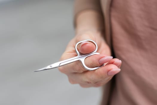 scissors in a hand on a white background. High quality photo