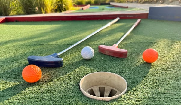 Golf ball and golf club on green in the evening golf course with sunshine . High quality photo