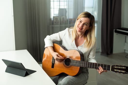 Young woman playing her guitar at home. High quality photo