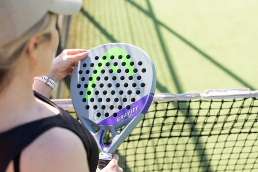 A girl with a paddle racket on an outdoor court. Concept of women playing paddle. Paddle sport. High quality photo Ukraine Kyiv, April 02 2024