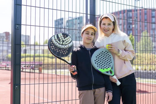 mother and daughter playing padel outdoor. High quality photo