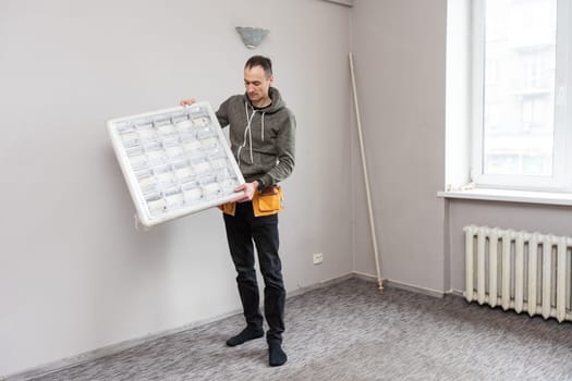 Maintenance man changing light bulbs in office. High quality photo