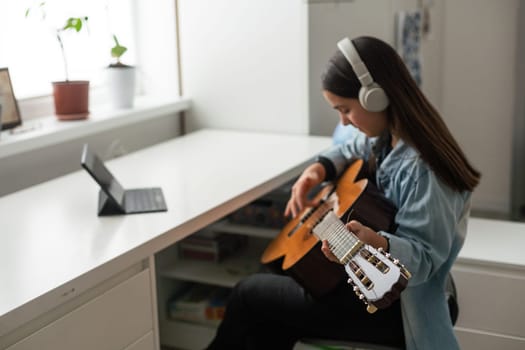 Portrait of smiling teen student practicing guitar during music lessons. High quality photo