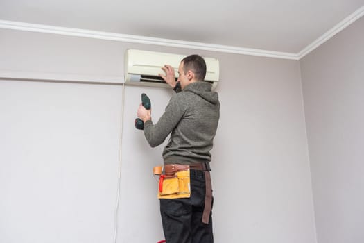 Male technician cleaning air conditioner indoors. High quality photo