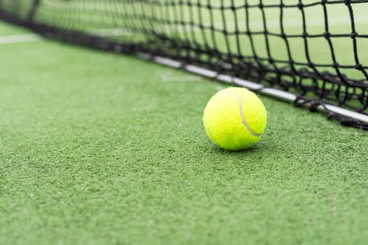 Tennis Ball on the Court against the Court Net. High quality photo