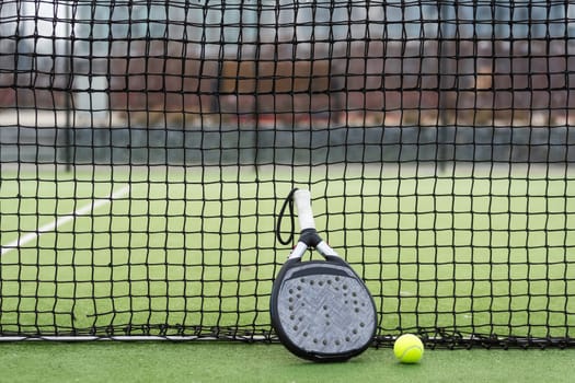 White professional paddle tennis racket with natural lighting on blue background. Horizontal sport theme poster, greeting cards, headers, website and app. High quality photo