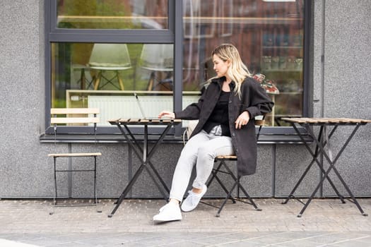 Businesswoman working with laptop in outdoor cafe. Corporate blog. High quality photo