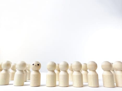 Wooden figurines with a leader and group with partial focus. The concept of distinguishing a leader from the crowd. Sighted, intelligent, different among the blind group