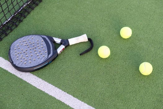 Paddle tennis racket, ball and net on the grass . High quality photo