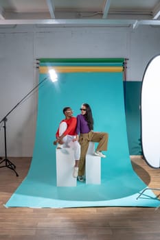 Two women pose on a color background cyclorama in a studio photo shoot. High quality photo